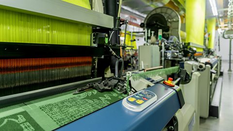 An industrial loom machine in a textile factory used for weaving fabric.