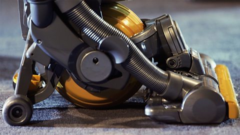 A close-up image of a modern Dyson vacuum cleanera with four wheels and a ball in the centre.