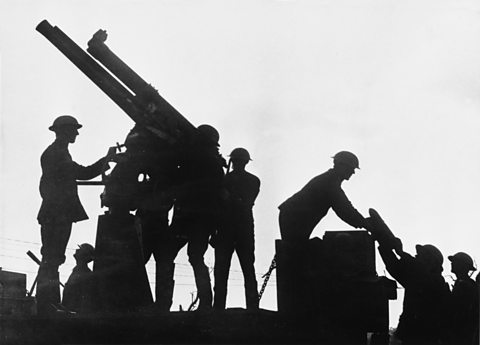 World War One soldiers in silhouette loading a weapon