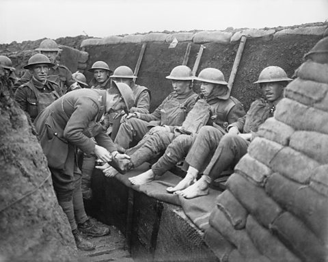 A soldier with a rifle in a trench in World War One