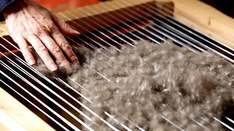 Galaxiid/Alamy Eiderdown is siftyed through a primitive stringed device called a harp (Credit: Galaxiid/Alamy)