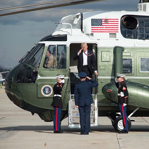 US President Donald Trump salutes as he steps off the Marine One helicopter.