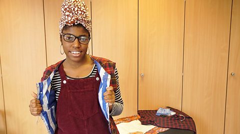 a young woman poses for the camera wearing a bomber jacket she has designed