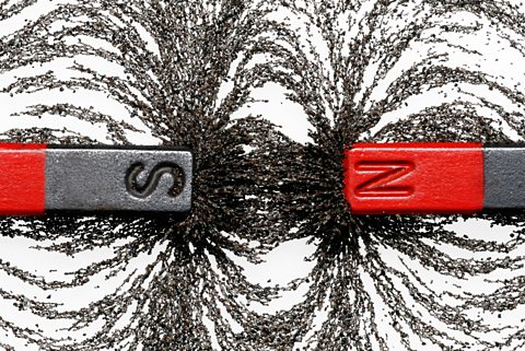 Two bar magnets with iron filings showing magnetic attraction between opposite poles