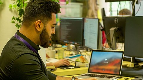 Inshal sits at his desk with a laptop open