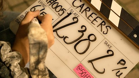 Tamsin writes a scene description on a clapper board that reads 'Careers'