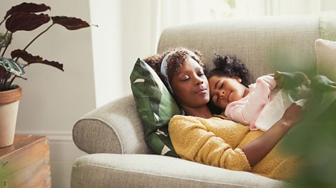 Mother and daughter sleeping on the sofa