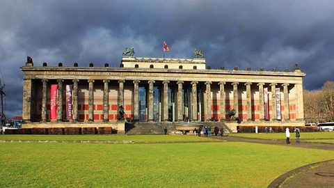 A museum with dark, stormy clouds in the background.