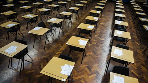 Getty Images Rows of empty desks fill a Welsh school hall, ready for GCSE school pupils to sit their exams (Credit: Getty Images)