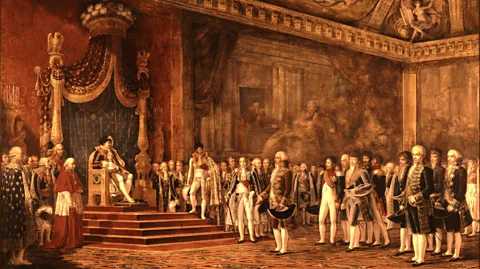 Alamy This painting of Napoleon in the Chateaux of Versailles in 1809 shows the French emperor seated while all around remain standing (Credit: Alamy)