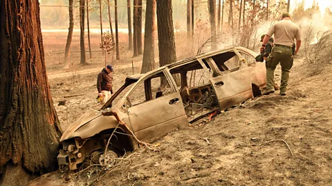 Getty County sheriff officers inspect a vehicle for remains; fires like this one, the Camp Fire, are too fast to be managed (Credit: Getty)