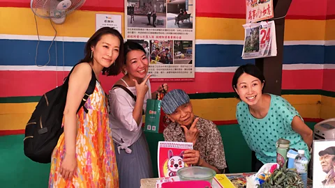 Eliot Stein Travellers pose for pictures with the artist in residence, Grandpa Rainbow (Credit: Eliot Stein)