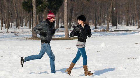 A young couple playing in the snow.