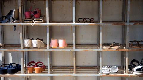 Bent metal angles used to construct a large, slightly rusting shoe rack.