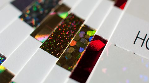 A close-up of several different cards hot foil stamped with bright and reflective pattern strips.