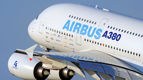An Airbus aeroplane is in take-off, angled upwards against a clear blue sky.