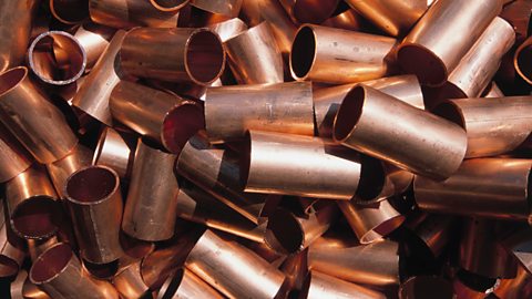 A pile of small lengths of metal copper piping.