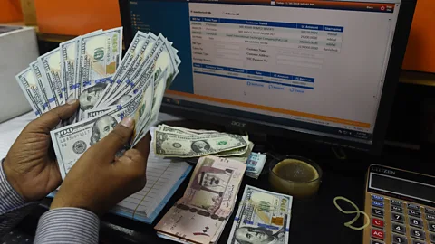 Getty Images A currency exchange shop in Pakistan. Depending on where you are in the world, different months have different effects on investor confidence (Credit: Getty Images)