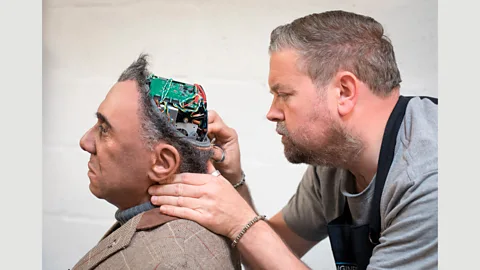 Getty Images Prosthetic expert Mike Humphrey checks on Fred, a Mesmer robot that was built by Engineered Arts in Cornwall, England (Credit: Getty Images)