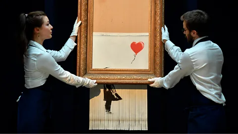 Getty Images Banksy timed a shredder to destroy Girl with Balloon just after it was sold at Sotheby’s auction house in London, creating new artwork Love is in the Bin (Credit: Getty Images)