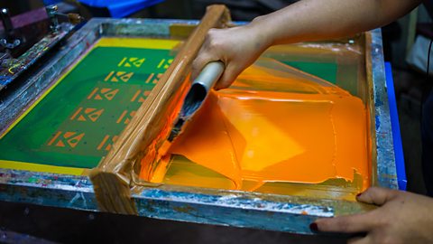 Flat-bed screen printing using orange ink.