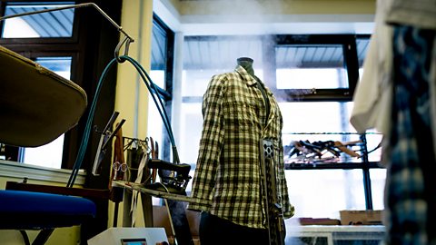 Steam rises out around a shirt on a dolly in a design studio.