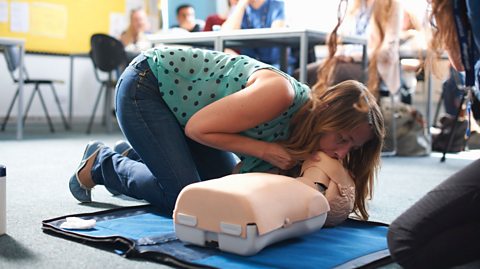 Woman giving CPR to a doll