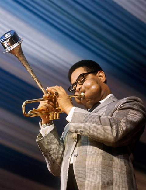 A photograph of Dizzy Gillespie on stage performing at a Jazz festival.