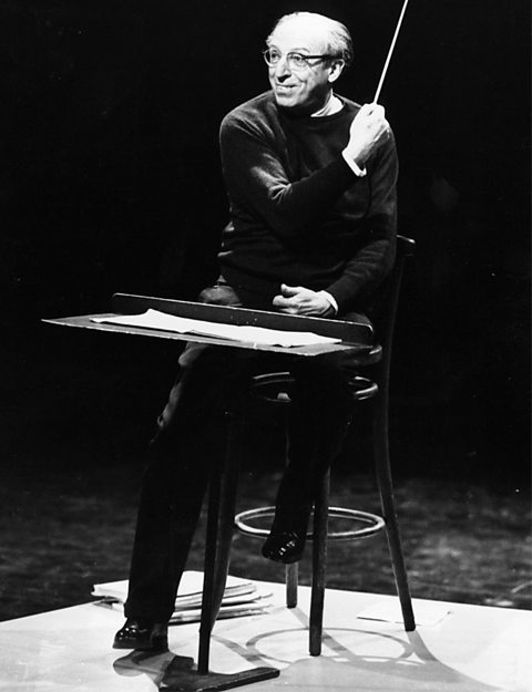 A black and white photograph of Aaron Copland conducting.