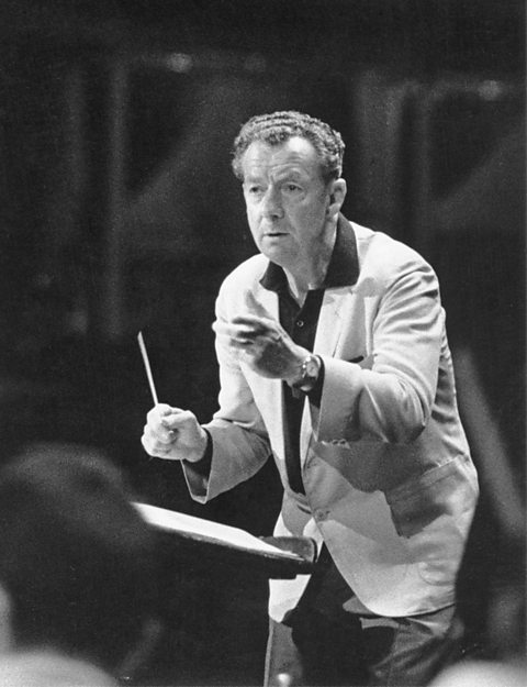 A photograph of Benjamin Britten conducting at the Royal Albert Hall.