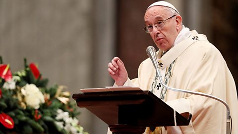 Pope Francis speaking from behind a lectern