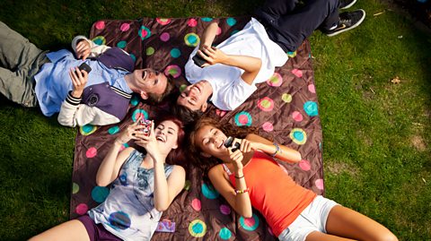 Teenagers using mobile phone and laughing