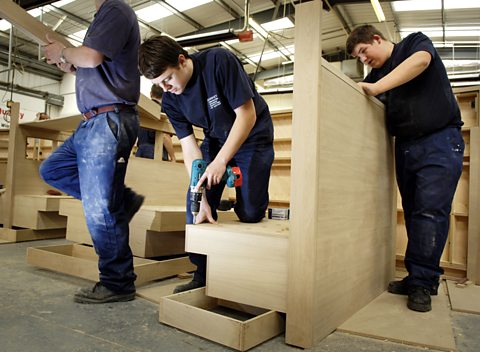 Apprentice joiners working in a factory