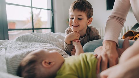 A boy talking to his baby brother at nappy change