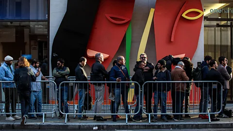 Getty Images Consumerism remains a cornerstone of our culture. Here, people queue for the new iPhone in London last year (Credit: Getty Images)