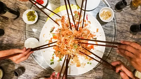 ThamKC/Getty Images It is believed that the higher the yu sheng is tossed, the more luck it attracts (Credit: ThamKC/Getty Images)