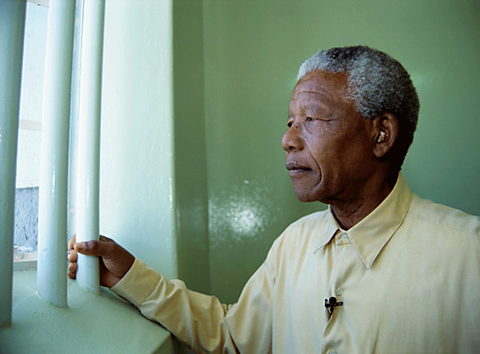 Nelson Mandela looking out of his old prison cell window. 