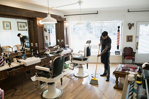 Man sweeping floor in barbers