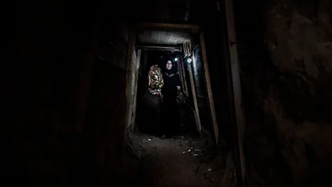 Tanya Habjouqa/NOOR Gaza, 30 June 2013: A woman walks through an underground tunnel on her way to a party in Egypt (Credit: Tanya Habjouqa/NOOR)