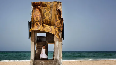 Tanya Habjouqa/NOOR Gaza, 30 June 2013: A young girl plays on the beach in the dress she wore to a wedding the night before (Credit: Tanya Habjouqa/NOOR)