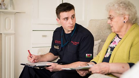 Sam talking to a lady in her home on a fire safety visit.