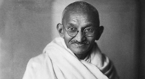 Black and white photograph of Ghandi in simple white cloth clothes