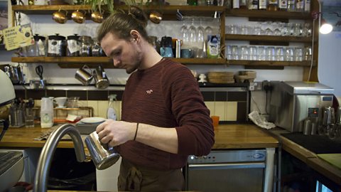 Zach pouring a drink in the coffee shop.