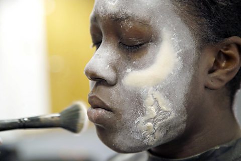 Amrita applying makeup to a model.