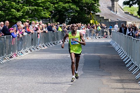 Photo of Kenyan runner Japhet Koech running in 2016 Edinburgh marathon with spectators cheering him 