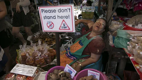 Getty Images A street vendor in Maeklong, Thailand surrounded by tourists (Credit: Getty Images)