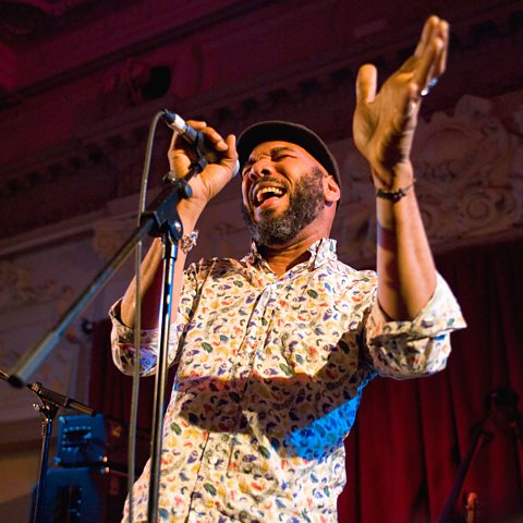 Anthony Joseph performing on stage with a microphone