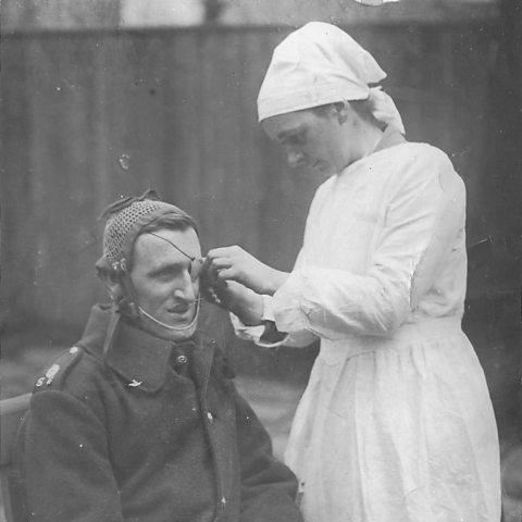 Photograph of Anne Acheson tending the eyepatch of a serviceman while working for the SRA