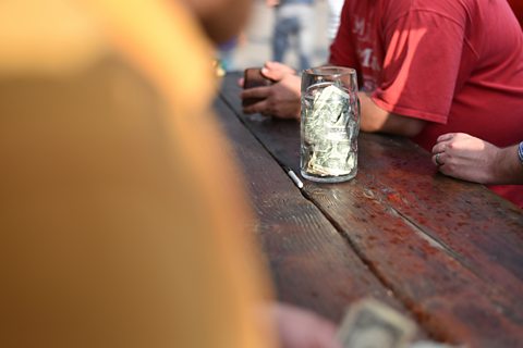 A tips jar on a bar counter.