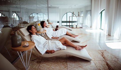 Spa guests in robes relaxing on loungers.
